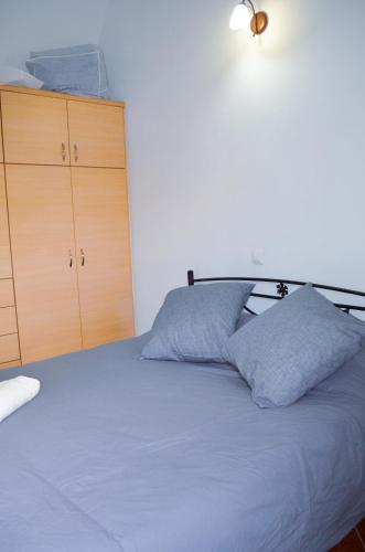 a bedroom with a bed with two blue pillows at Bluegonia in Éxo Goniá