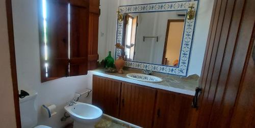 a bathroom with a sink and a mirror and a toilet at Montinho do Palanque in Viana do Alentejo
