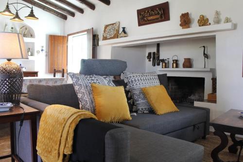 a living room with a couch and a fireplace at Montinho do Palanque in Viana do Alentejo