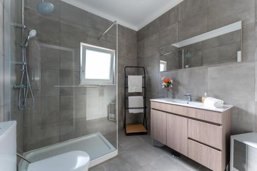 a bathroom with a sink and a toilet and a tub at Lagos - Pool & Garden in Lagos