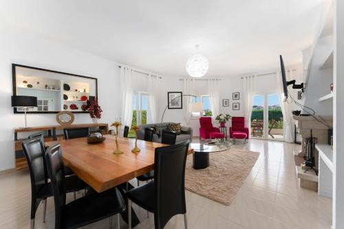 a dining room and living room with a table and chairs at Lagos - Pool & Garden in Lagos