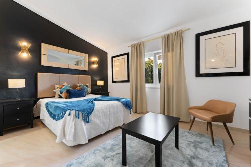 a bedroom with a bed and a chair and a table at Lagos - Pool & Garden in Lagos