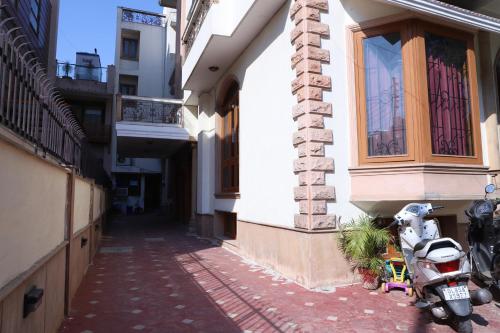 an alley with a scooter parked next to a building at Hotel Ashray Noida in Noida