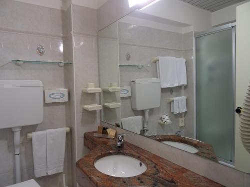 a bathroom with two sinks and a large mirror at Hotel Garden in Cervia