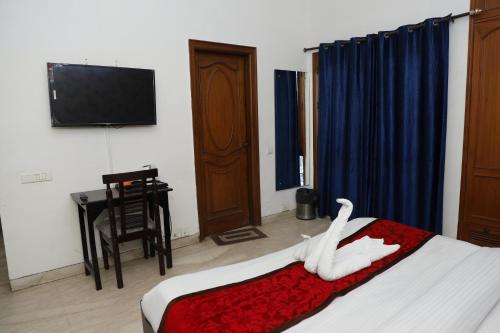 a bedroom with a bed with a white swan on it at Hotel Ashray Noida in Noida