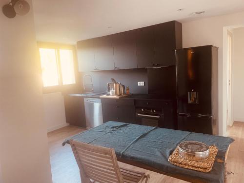 Il comprend une cuisine équipée d'une table et d'un réfrigérateur noir. dans l'établissement T3 dans charmante propriété, à Borgo