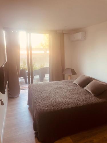 une chambre avec un lit et une grande fenêtre dans l'établissement T3 dans charmante propriété, à Borgo