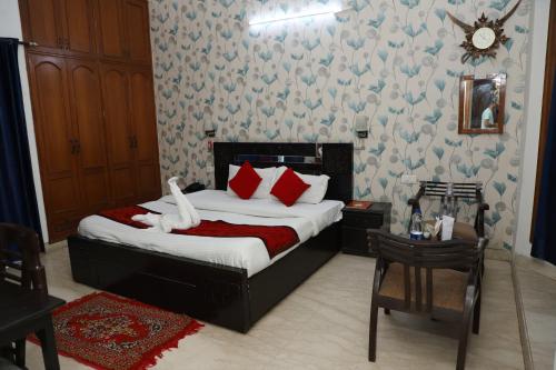 a bedroom with a bed with red and white pillows at Hotel Ashray Noida in Noida