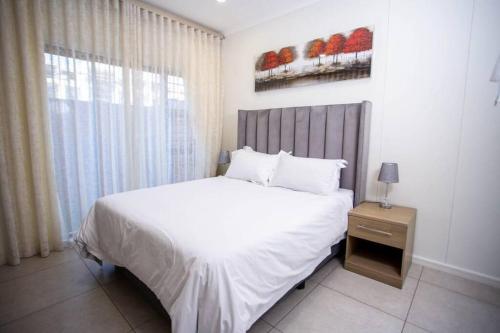 una camera da letto con un grande letto bianco e una finestra di Lovely morden 1 bedroom cozy apartment a Lombardy East