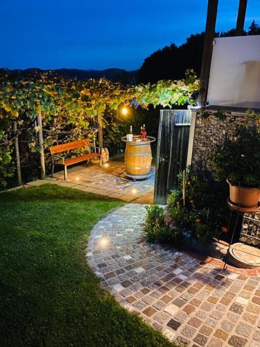 a patio with a table and a bench and a wine barrel at Ferienhaus Ulrichsbrunn in Hartmannsdorf