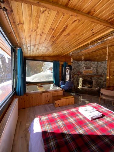 1 dormitorio con 1 cama y chimenea en una habitación en Ayder Şelale Dağ Evleri, en Ayder