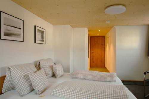 a bedroom with a bed with checkered pillows at Hotel Landgasthaus Neues Bild, Eggerstanden in Appenzell