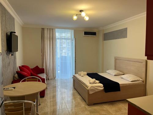 Schlafzimmer mit einem Bett, einem Tisch und Stühlen in der Unterkunft Orbi apartamenti batumi 15 b in Batumi