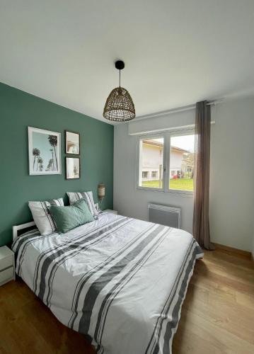 a bedroom with a large bed and a window at L'Ocenoa2 in Mimizan