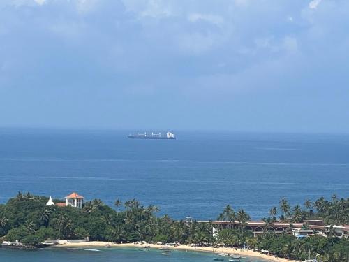 a cruise ship in the ocean next to a beach at Kapaliya Unawatuna in Unawatuna