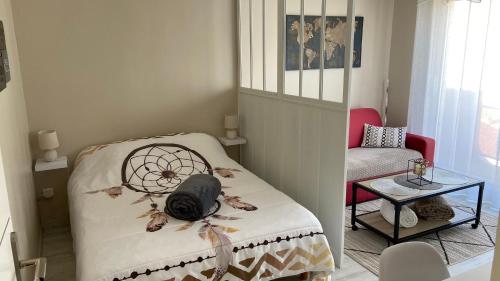 a bedroom with a bed and a table with a chair at Charmant Studio 25 m2, 900m de la plage in Les Sables-dʼOlonne