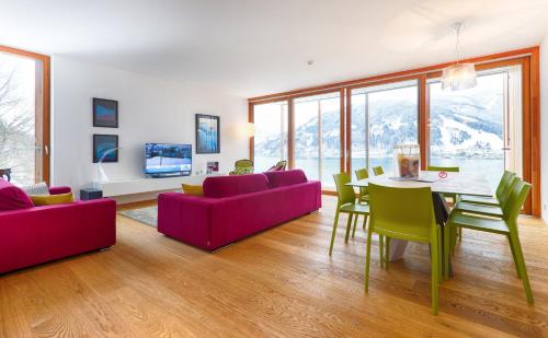 a living room with a table and chairs and a couch at Residence Bellevue - incl Summercard in Zell am See