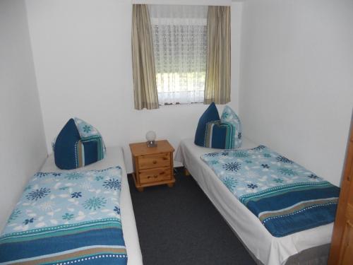 two twin beds in a room with a window at Ferienhaus Vorwachs 1 in Schwielochsee