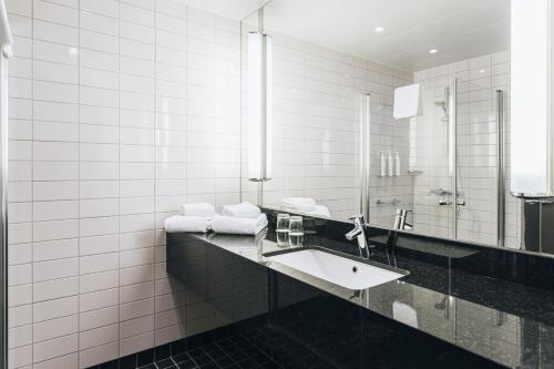 a bathroom with a sink and a mirror at Courtyard by Marriott Stockholm Kungsholmen in Stockholm