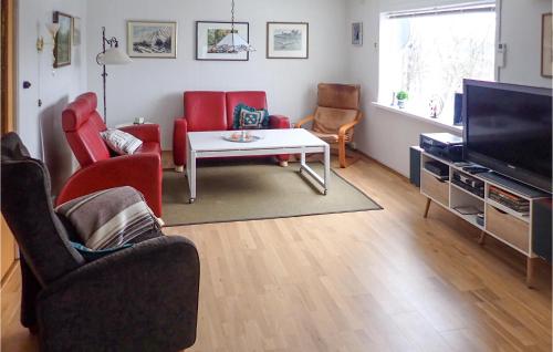 a living room with red chairs and a television at Amazing Home In Tau With House Sea View in Tau