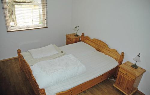 タウにあるStunning Home In Tau With 4 Bedrooms And Wifiのベッドルーム1室(木製ベッド1台、ナイトスタンド2台付)
