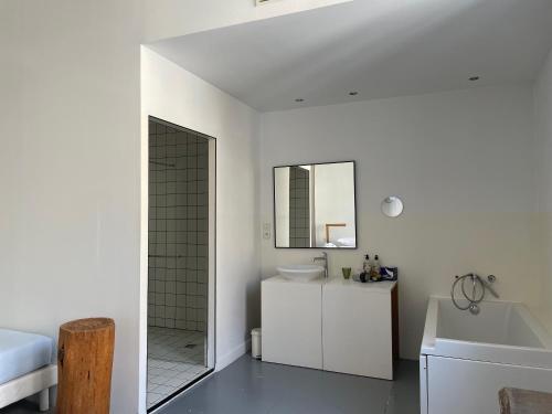 a white bathroom with a sink and a mirror at B&B Bloc G in Carcassonne