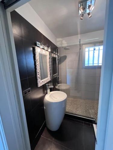une salle de bain avec des toilettes blanches et un lavabo dans l'établissement Appartement avec terrasse, vue jardin et piscine, à Antibes