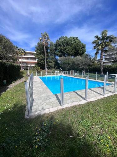 une grande piscine bleue dans un parc dans l'établissement Appartement avec terrasse, vue jardin et piscine, à Antibes
