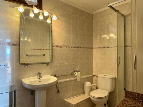 La salle de bains est pourvue d'un lavabo, de toilettes et d'un miroir. dans l'établissement Casa Mas Tomasi, à Pals