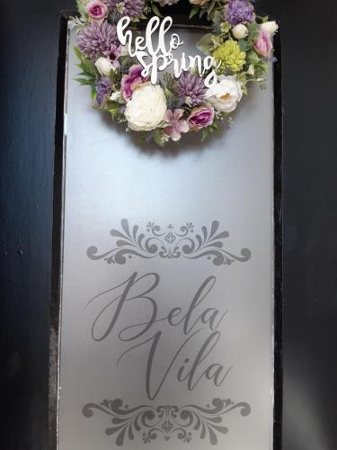 a cake with a flower wreath on top of it at Bela Vila in Negotin