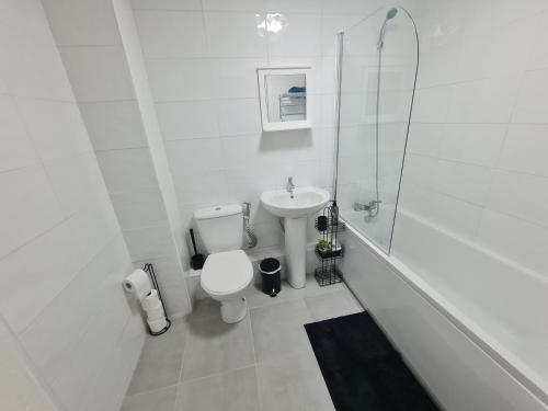 2 bedroom light, spacious aptmnt nr Heathrow في Cranford: حمام ابيض مع مرحاض ومغسلة