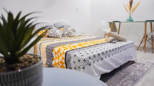 聖康坦的住宿－AppartCosy-StQuentin，一间卧室配有一张床和盆栽植物