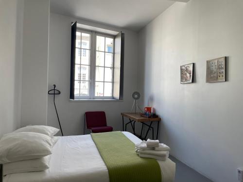 a bedroom with a bed and a window and a chair at B&B Bloc G in Carcassonne