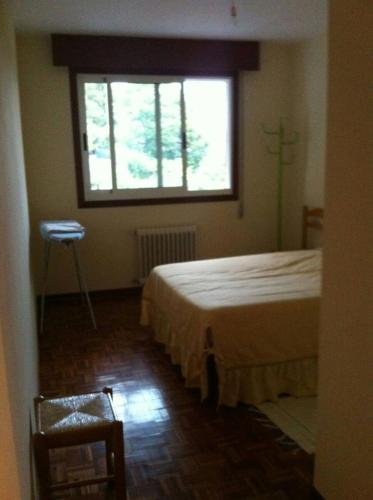 1 dormitorio con cama y ventana grande en Vacacions nas Neves - Holidays, en Nieves