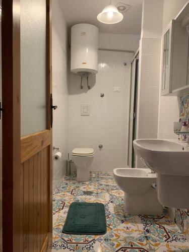 bagno con lavandino, servizi igienici e specchio di Al Castello Apartment a Fiumefreddo Bruzio