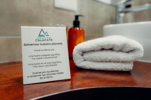 a sign sitting on a table with towels on a counter at Destino Calafate in El Calafate
