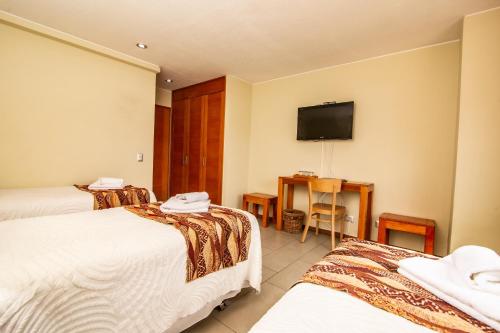a hotel room with two beds and a flat screen tv at Vientos del Sur in Pucón