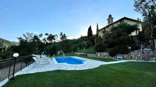 a yard with a swimming pool in front of a house at Agriturismo a Canonica in Garlenda