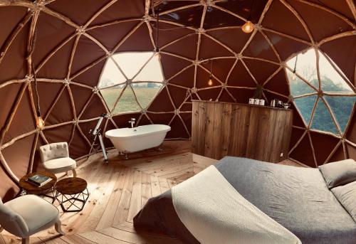 a igloo room with a bed and a tub and a sink at Little Wood Lodges in Bailly-aux-Forges