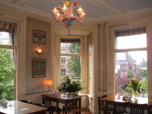 a dining room with two tables and a chandelier at Hotel Museumzicht in Amsterdam