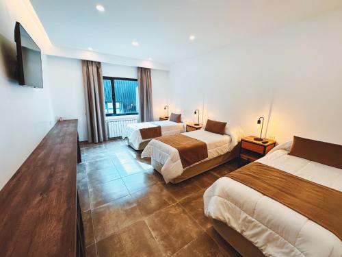 埃爾卡拉法特的住宿－Destino Calafate，酒店客房设有两张床和一台平面电视。