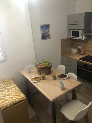 une cuisine avec une table avec un bol de fruits dessus dans l'établissement Au coeur de ville avec terrasse, à Céret