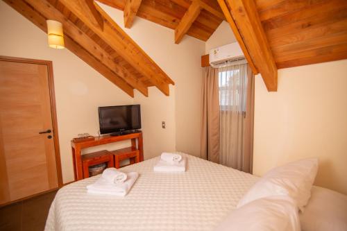 a bedroom with a bed with two towels on it at Vientos del Sur in Pucón