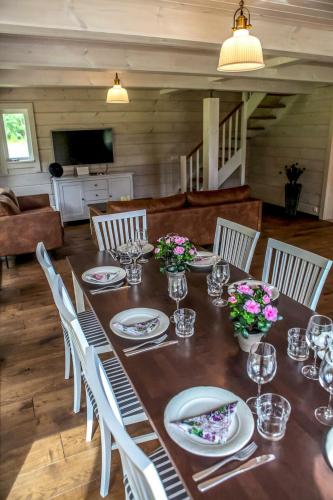 a dining room table with white chairs and flowers on it at Villa Pillapalu in Pillapalu