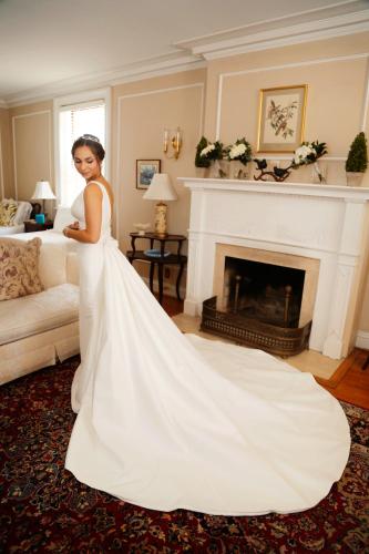 a woman in a wedding dress standing in front of a fireplace at Hornsby House Inn in Yorktown