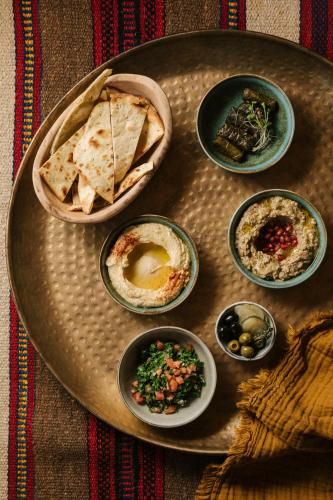een bord met verschillende soorten voedsel op een tafel bij Our Habitas AlUla in Al Ula