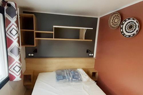 um pequeno quarto com uma cama e prateleiras em MH 127 Bois Dormant 3ch climatisé em Saint-Jean-de-Monts