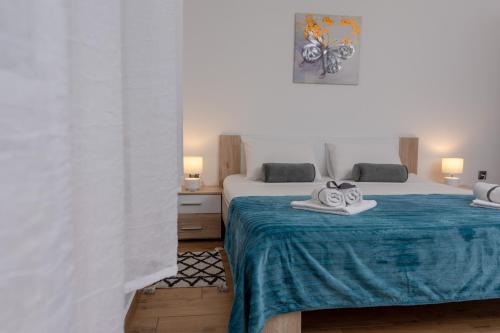 a bedroom with two beds with towels on a blue blanket at Blue Mile Apartman Split in Split