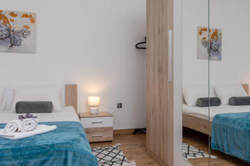um pequeno quarto com 2 camas e um espelho em Blue Mile Apartman Split em Split