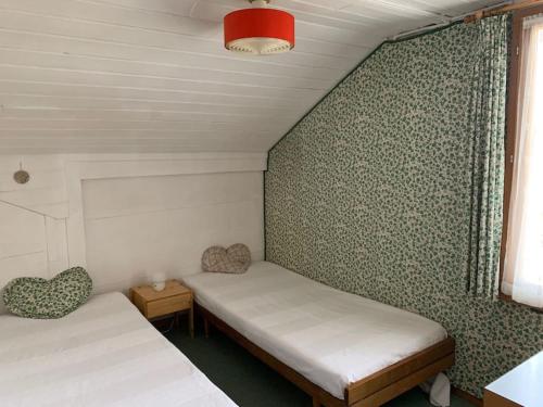 a small room with two beds and a window at Cozy apartment in center Lenk in Lenk